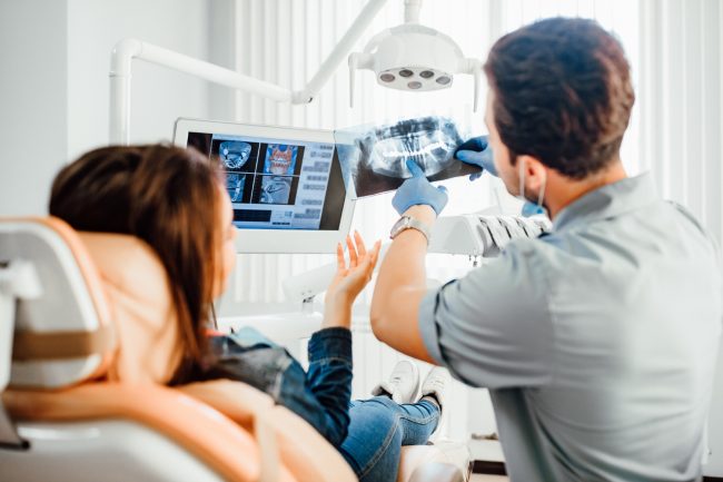 Concept per terapia ortodontica: ortodontista mostra alla paziente una lastra della dentatura - Dott.ssa Chiara Piccioni