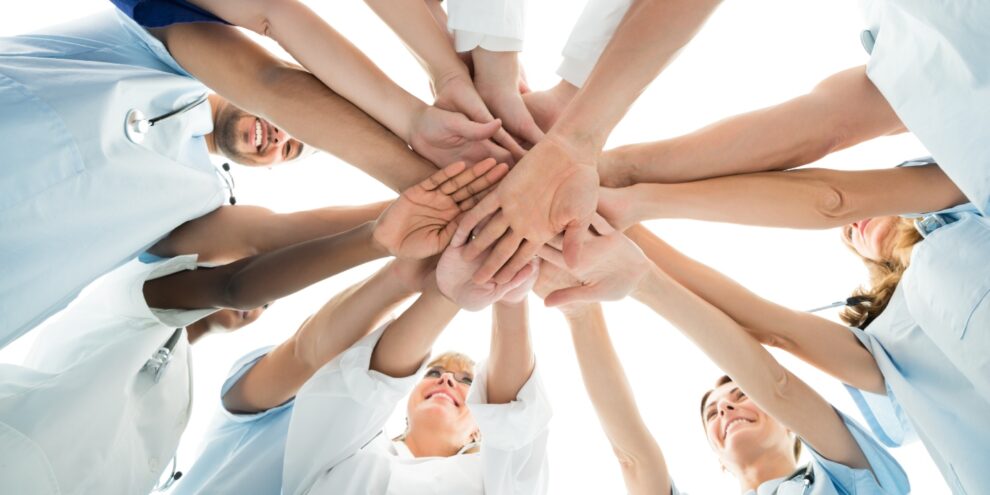 medici che uniscono le mani a cerchio. Concept per il team multidisciplinare dell'ortodontista
